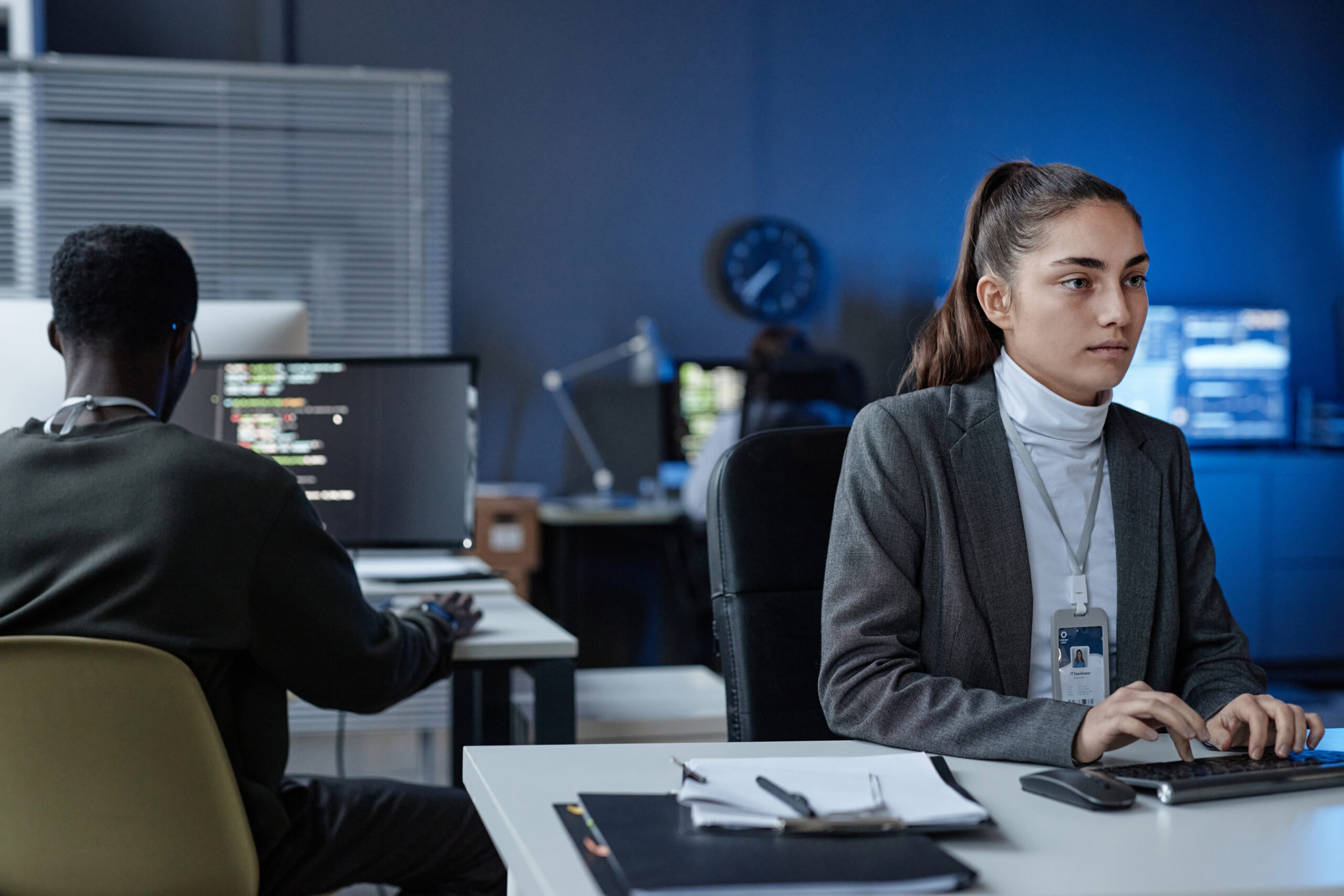 Woman Using Computer in Office with Blue Neon